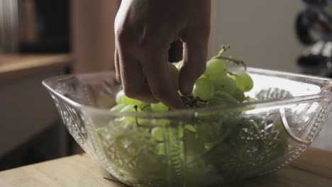 toronto, canadá - recogida manual de uvas verdes frescas en un cuenco cuadrado de cristal - toma de primer plano
