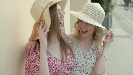 two young women wearing summer hats and dresses