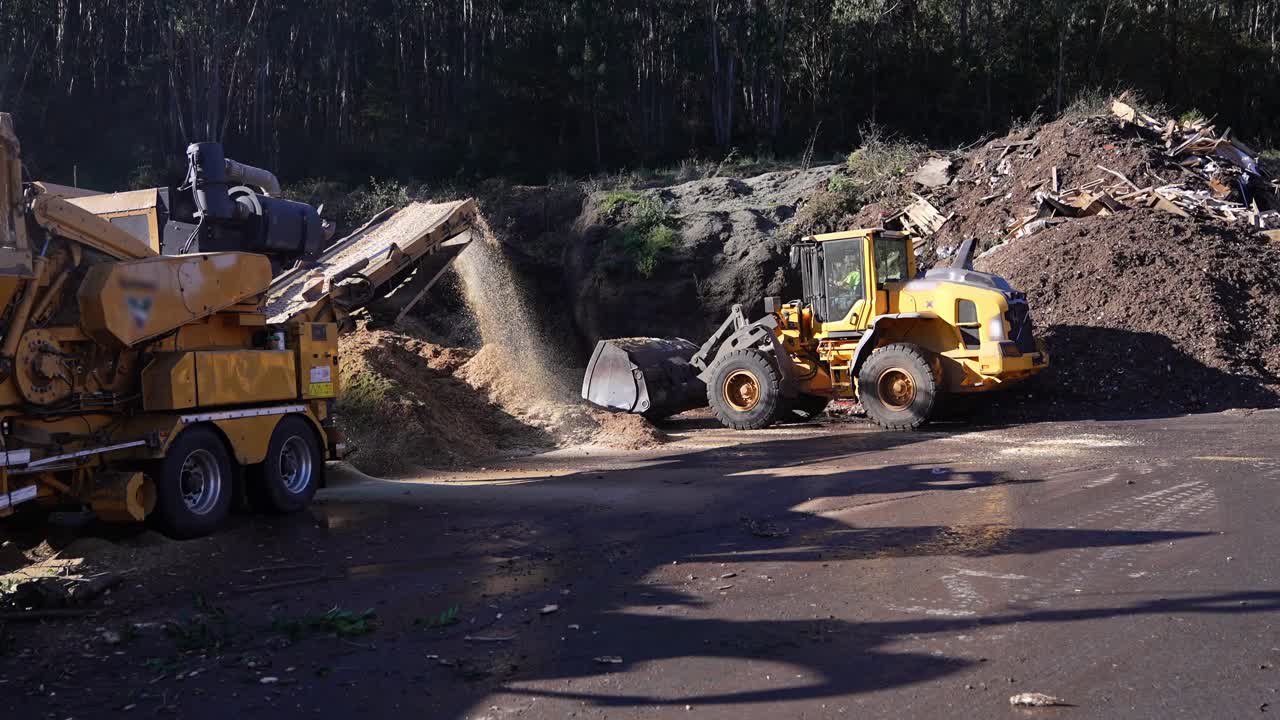 Wood chipping operation with bulldozer and machinery