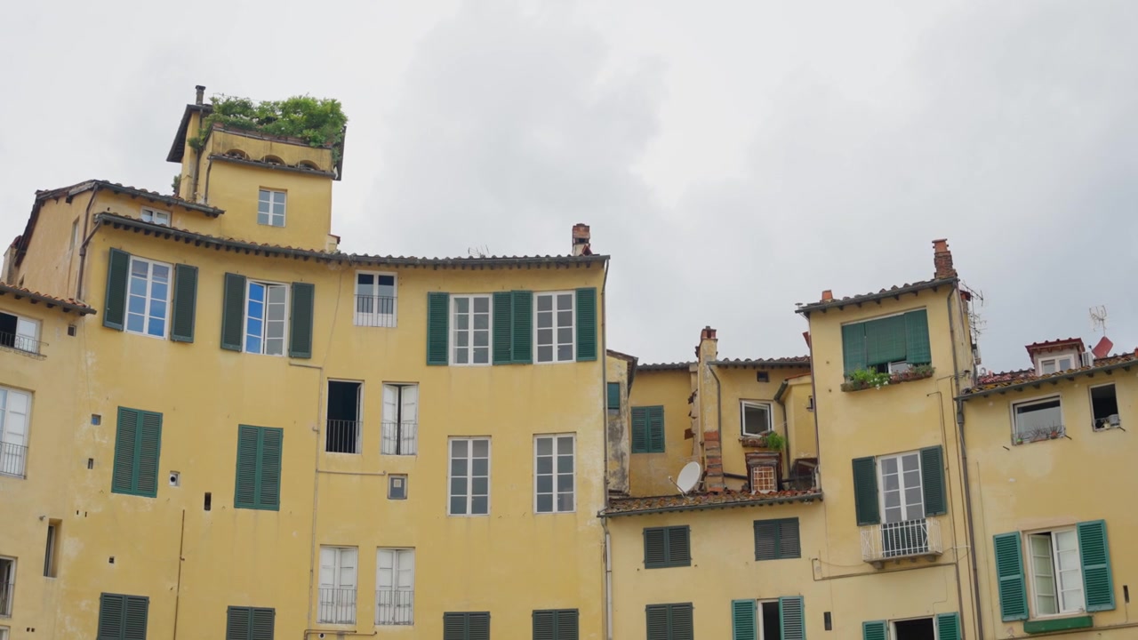 Edifícios na cidade italiana de Lucca. Famosa Piazza dell'Anfiteatro. Marco antigo ao lado de valor histórico e casas modernas. Centro da cidade e ponto turístico para visitantes e locais na cidade velha