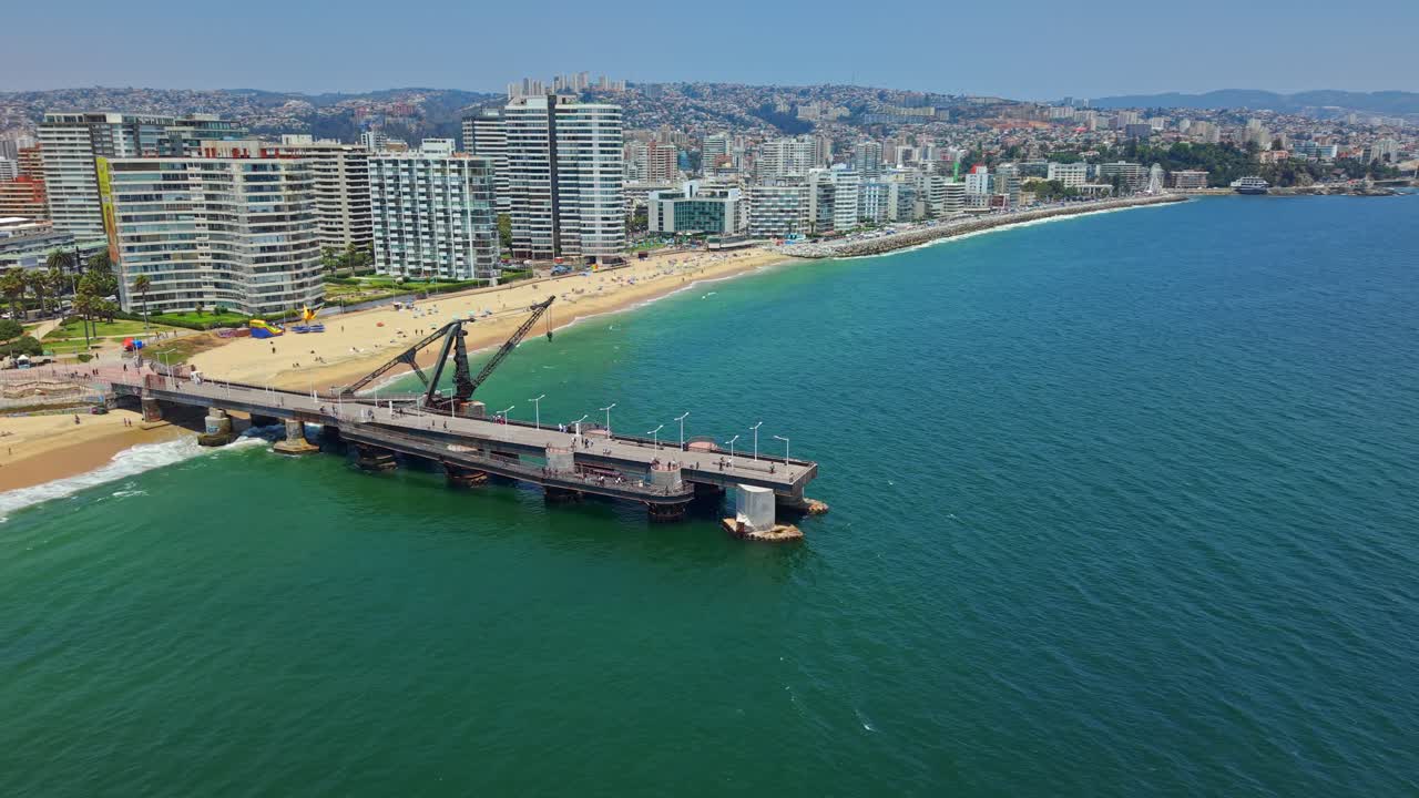 Bird's-eye view of Viña del Mar on a sunny day with the Vergara Pier and Acapulco Beach, residential buildings on the beachfront, Chile