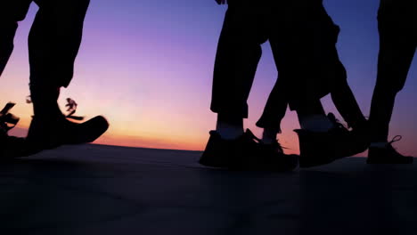 silhouettes of people walking at sunset or sunrise