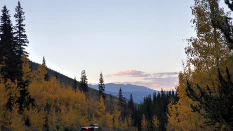 autumn sunset in mountains with vehicle traveling