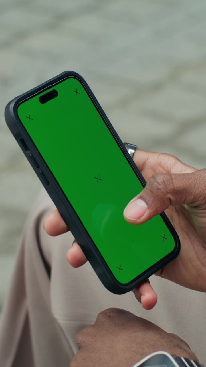 persona que sostiene un teléfono inteligente con una pantalla verde