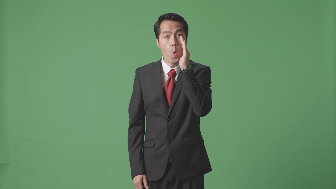 스튜디오에서 녹색 스크린 배경에 ooh 얼굴을하는 아시아 사업가