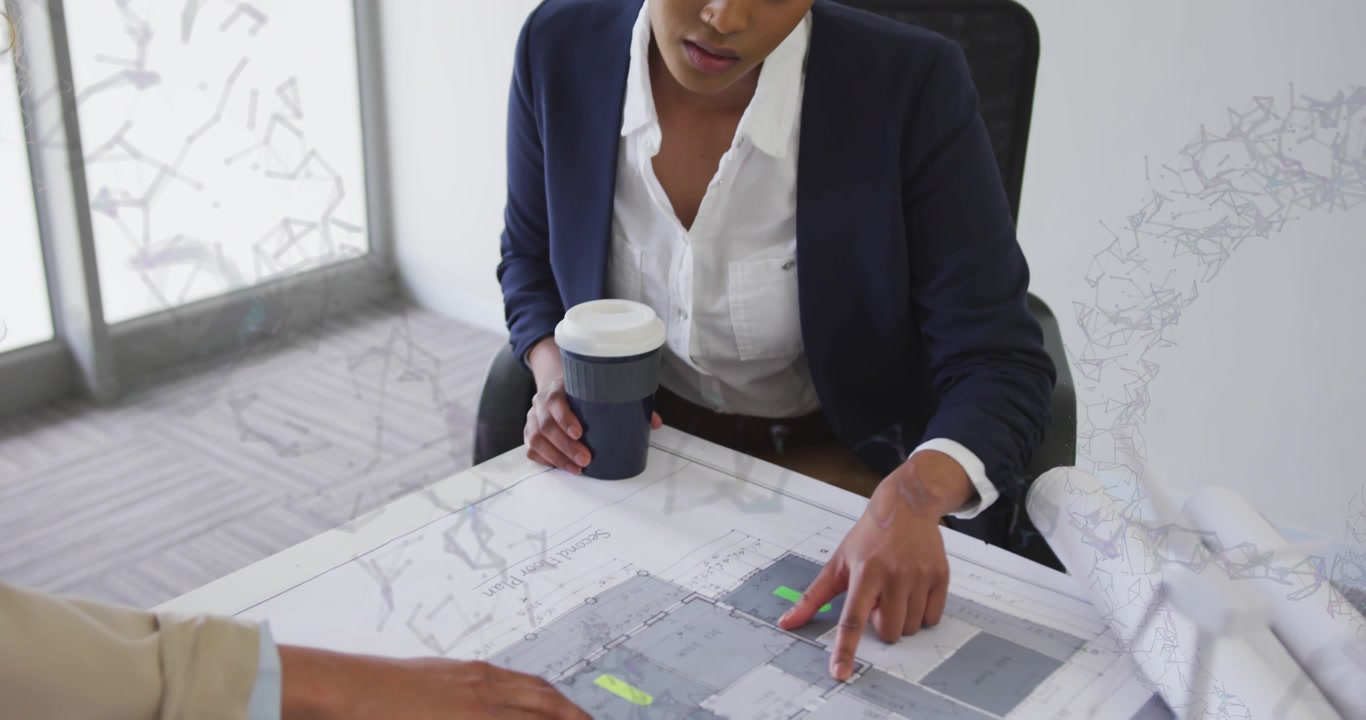 designer pressing yellow tab onto blueprint while architect holding coffee and coordinating layout