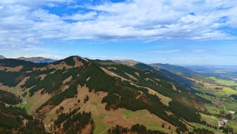 beautiful mountains crossed by trekking trails among the pine tree woods. bolsterlang, bavaria, germany is at the rock foot. aerial view.