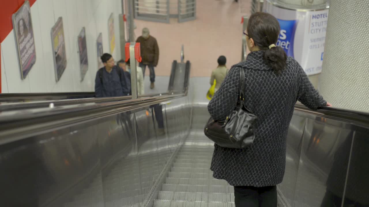 People riding an escalator in a busy indoor metro station
