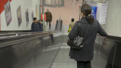 people riding an escalator in a busy indoor metro station