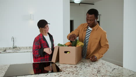 man receiving box of vegetables