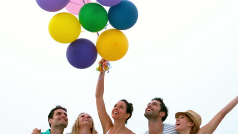 smiling friends holding balloons