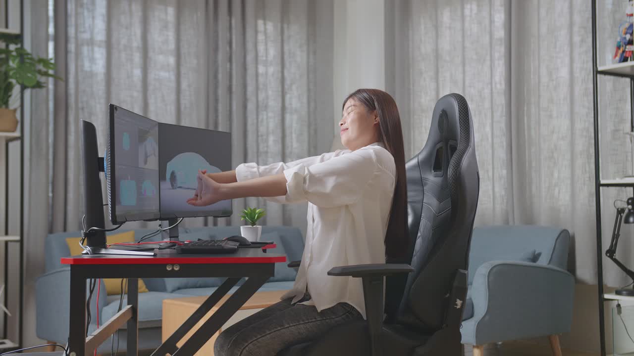 아시아 여성 자동차 디자이너가 스튜디오의 데스크 컴퓨터에서 ev 자동차의 3d 모델을 작업하는 동안 스트레칭하는 측면 뷰
