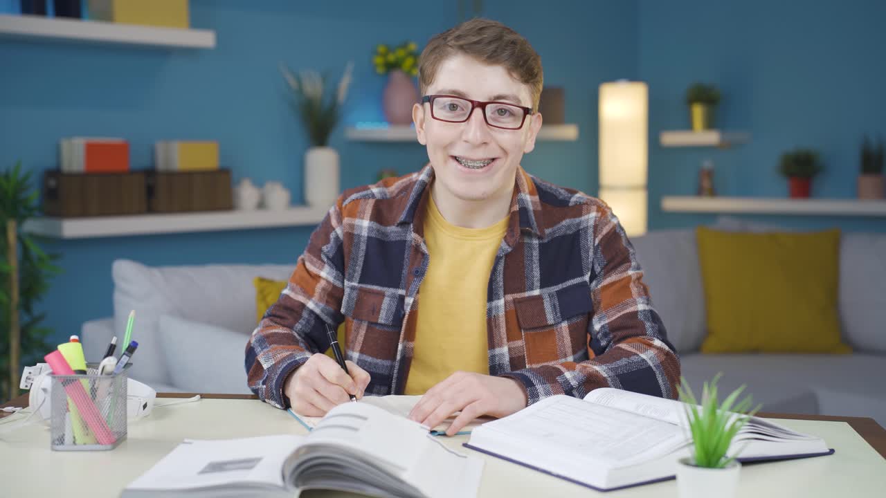 O jovem que gosta das aulas ri para a câmera