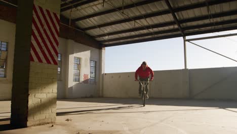 jinete de bmx en un almacén vacío