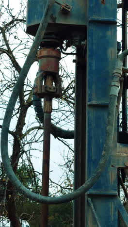 drilling equipment works outdoors. special machine boring the well. vertical video.