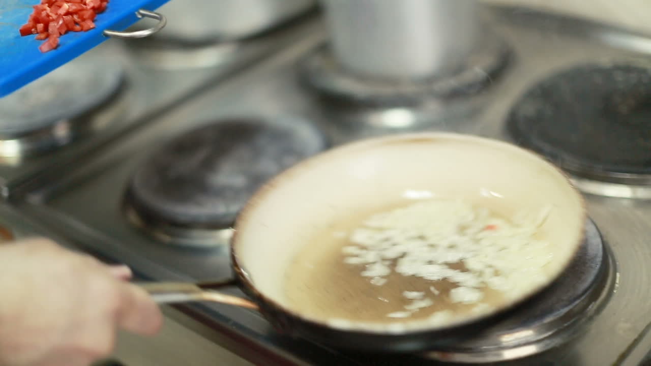 Onion Frying In A Pan. Fried onions in a frying pan in oil, for cooking