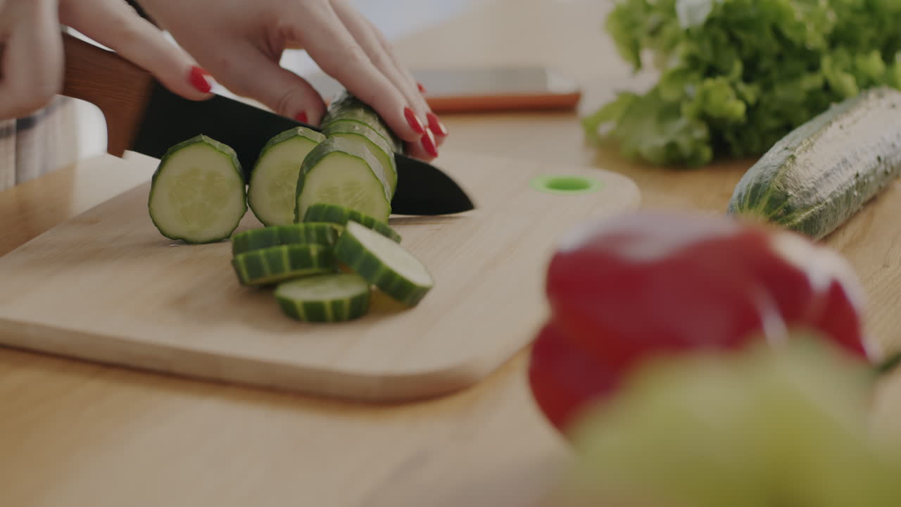 женщина, разрезающая огурцы.