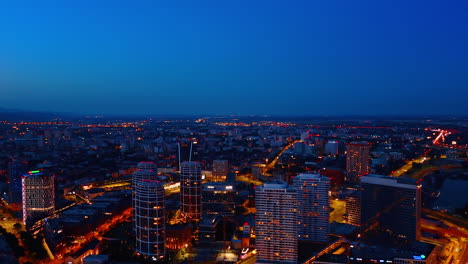 flying over the modern part of bratislava, slovakia at dusk time. beautiful city scenery with street lights on