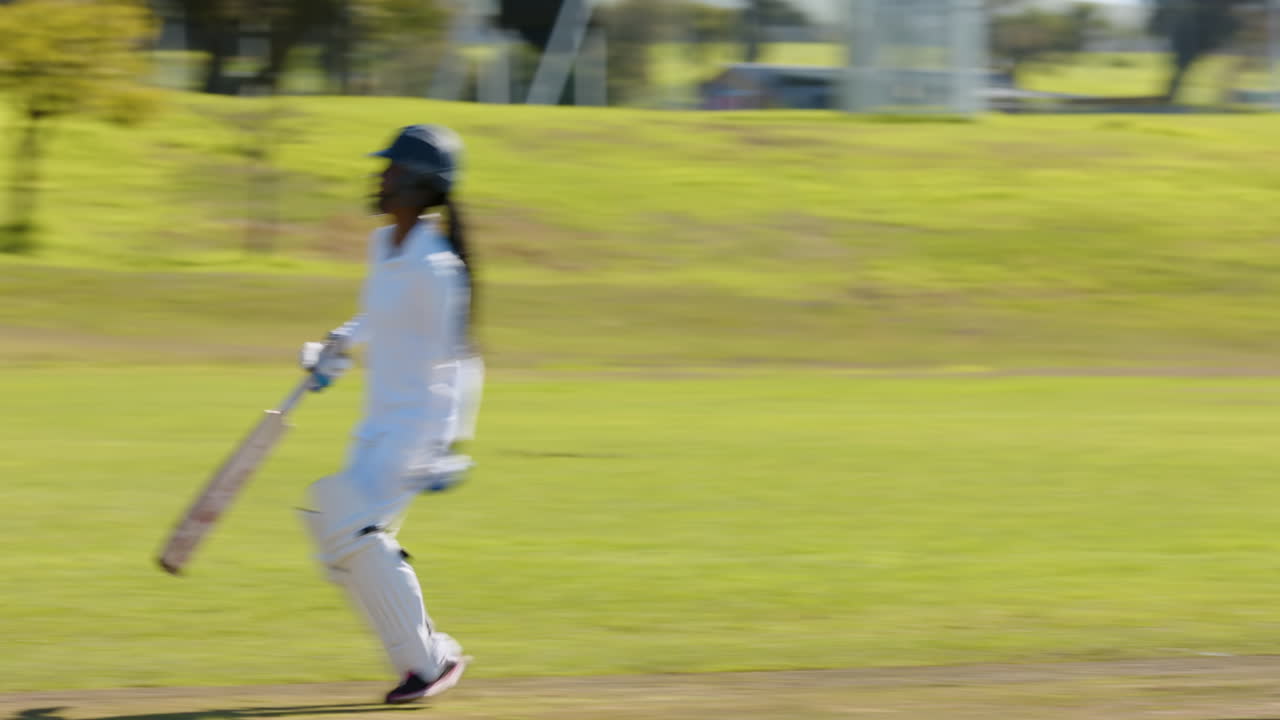Playing cricket on sunny day, woman running on green field