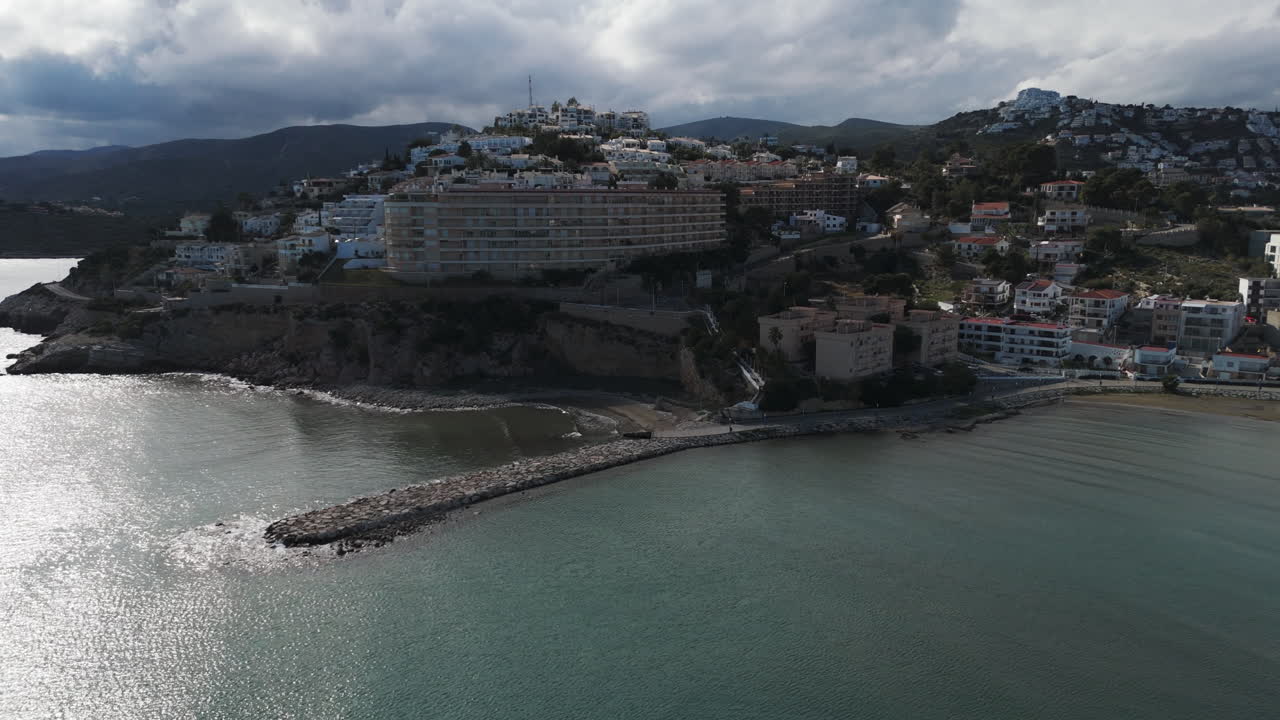 Aerial tilt showing coast of Playa Sur in Peniscola with cloudy weather and wide beach
