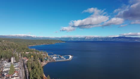 Drone-aerial-view-of-a-marina-on-Lake-Tahoe,-and-Mount-Houghton-in-the-distance