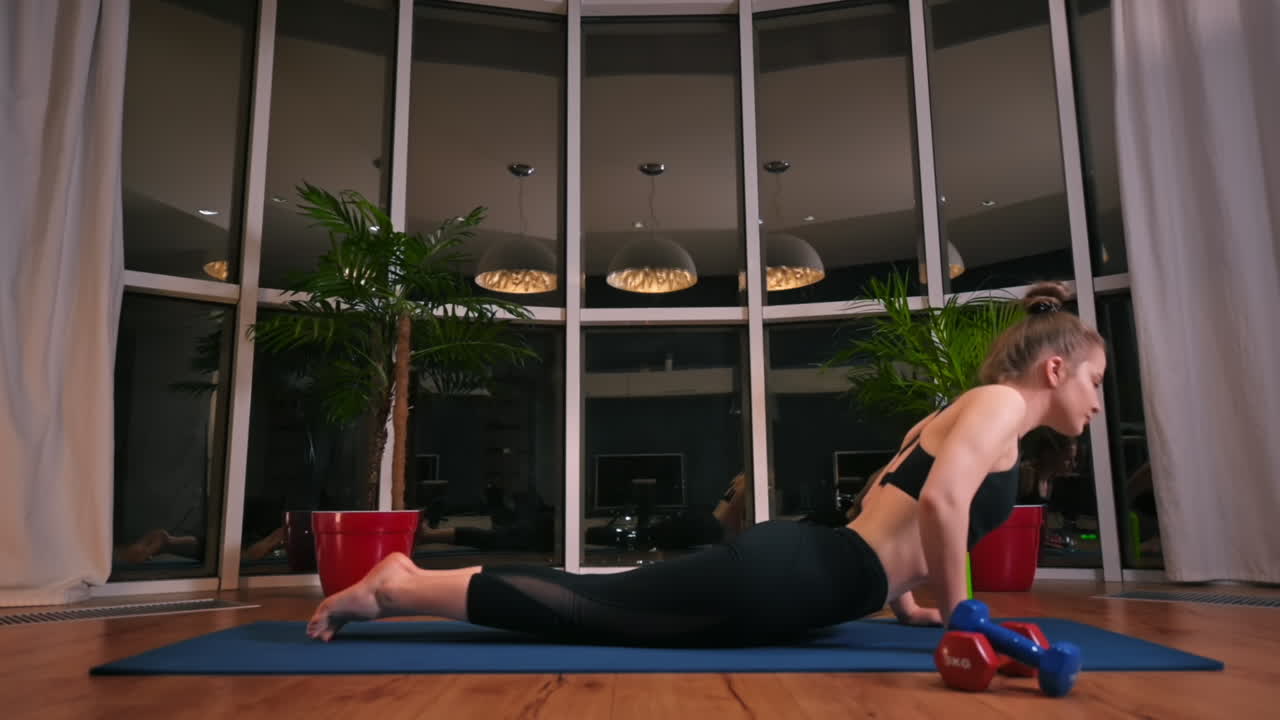Young woman girl doing cobra movement in yoga. City on background. Night