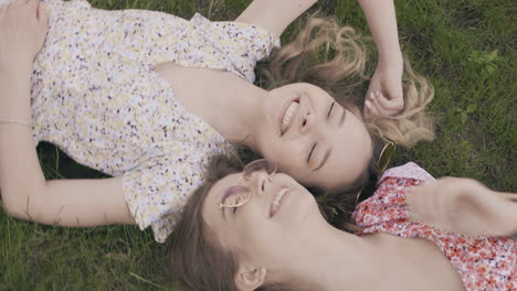 two happy girls lying on the grass