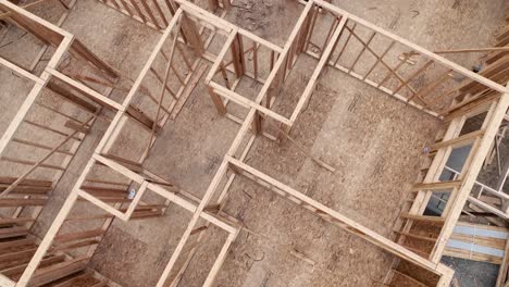 aerial pushing through a framed house in need of a roof