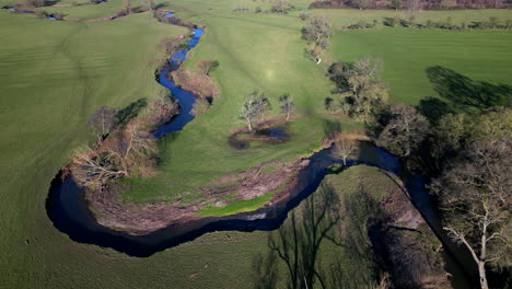 The-twisting-river-Arrow-running-through-the-winter-countryside-of-Warwickshire,-England