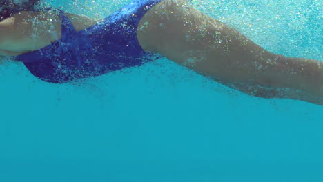 woman in blue bathing suit swimming underwater