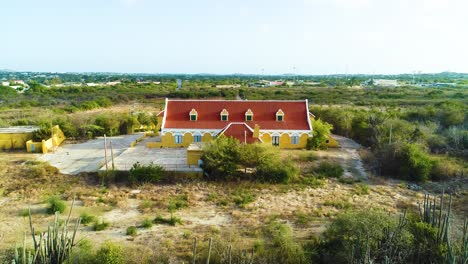 Drone-Se-Eleva-Detrás-De-Un-Paisaje-Seco-De-Cactus-Para-Establecer-Landhuis-Brievengat-Curacao