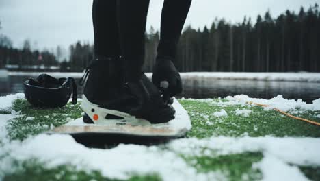 strapping on wakeboard bindings in snowy environment