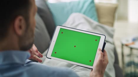 video de un hombre usando una tableta con una pantalla verde