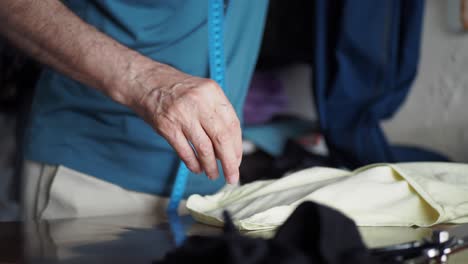 a tailor carefully examining and preparing fabric