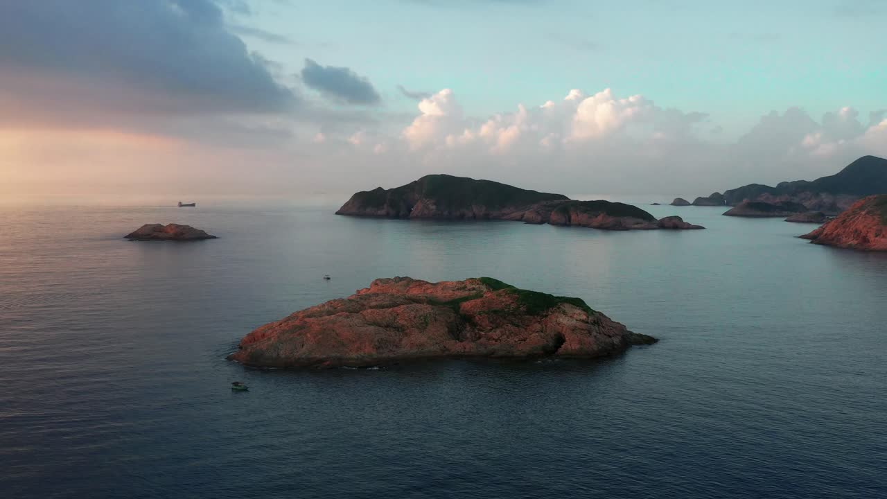 Aerial view of islands and coastline at Sai Kung National Park. Beautiful sunset over ocean in Hong Kong. Aerial drone fly over small islands in Sai Kung, Hong Kong