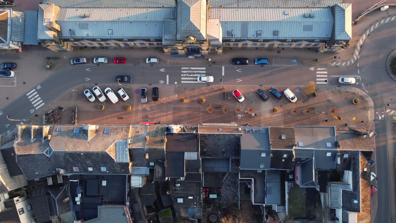 Aerial view of a European town square with parked cars and buildings