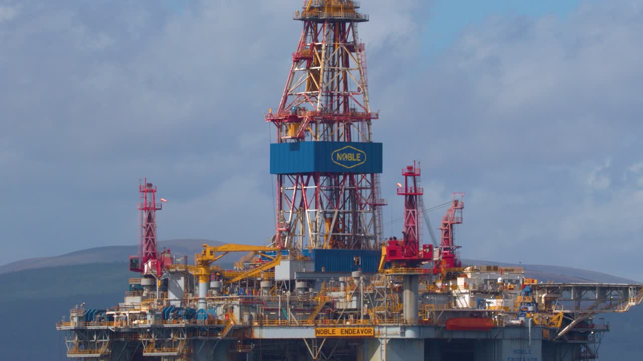 Stor offshore olieplatform bevæger sig langsomt mod Cromarty i Skotland i klart dagslys