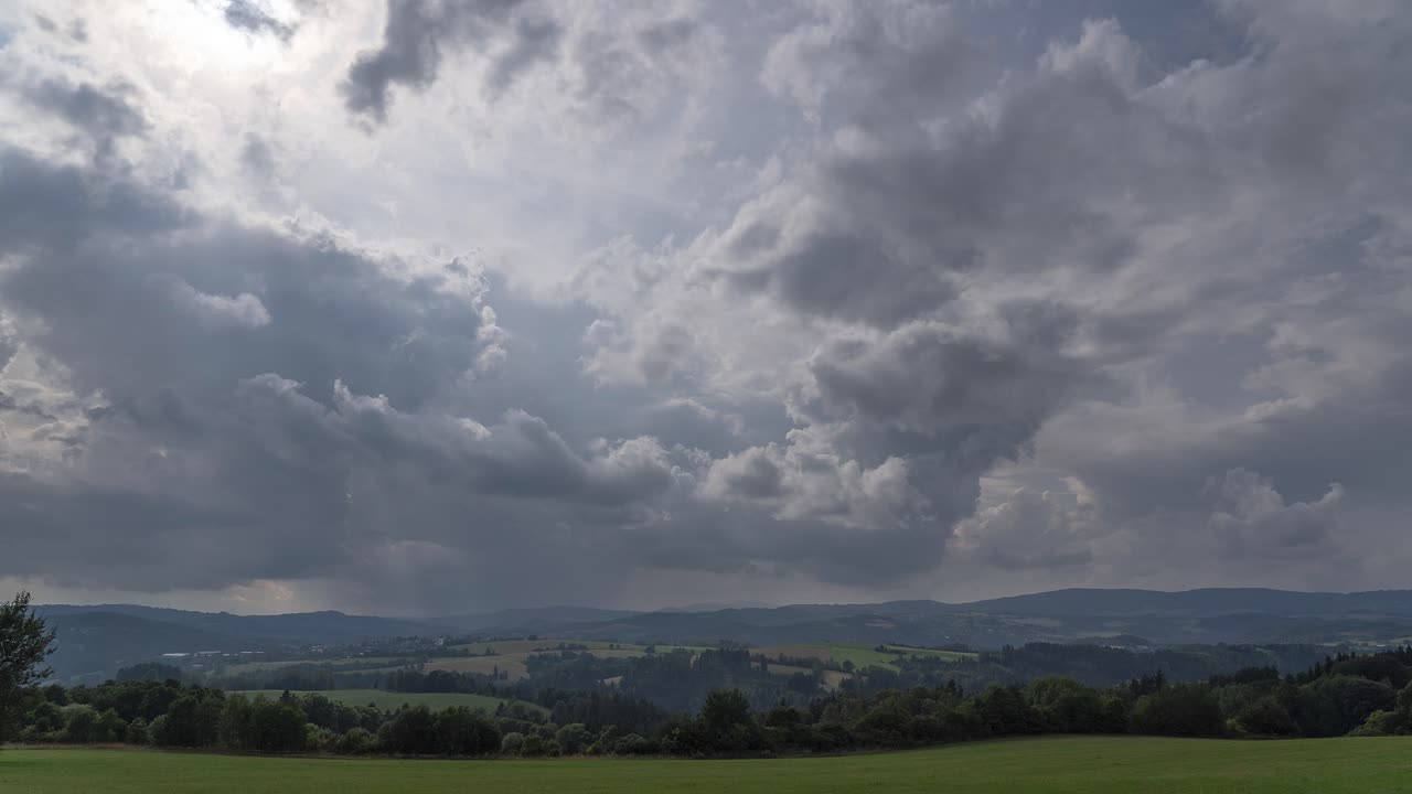 태양에 의해 백라이트 비 구름은 시골 여름 풍경 위에 굴러
