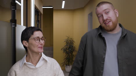 businesspeople in conversation in an office corridor