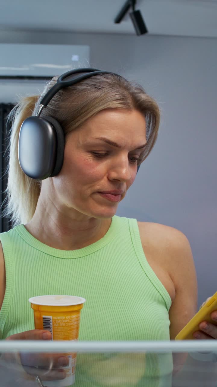 Woman Drinking Something While Wearing Headphones