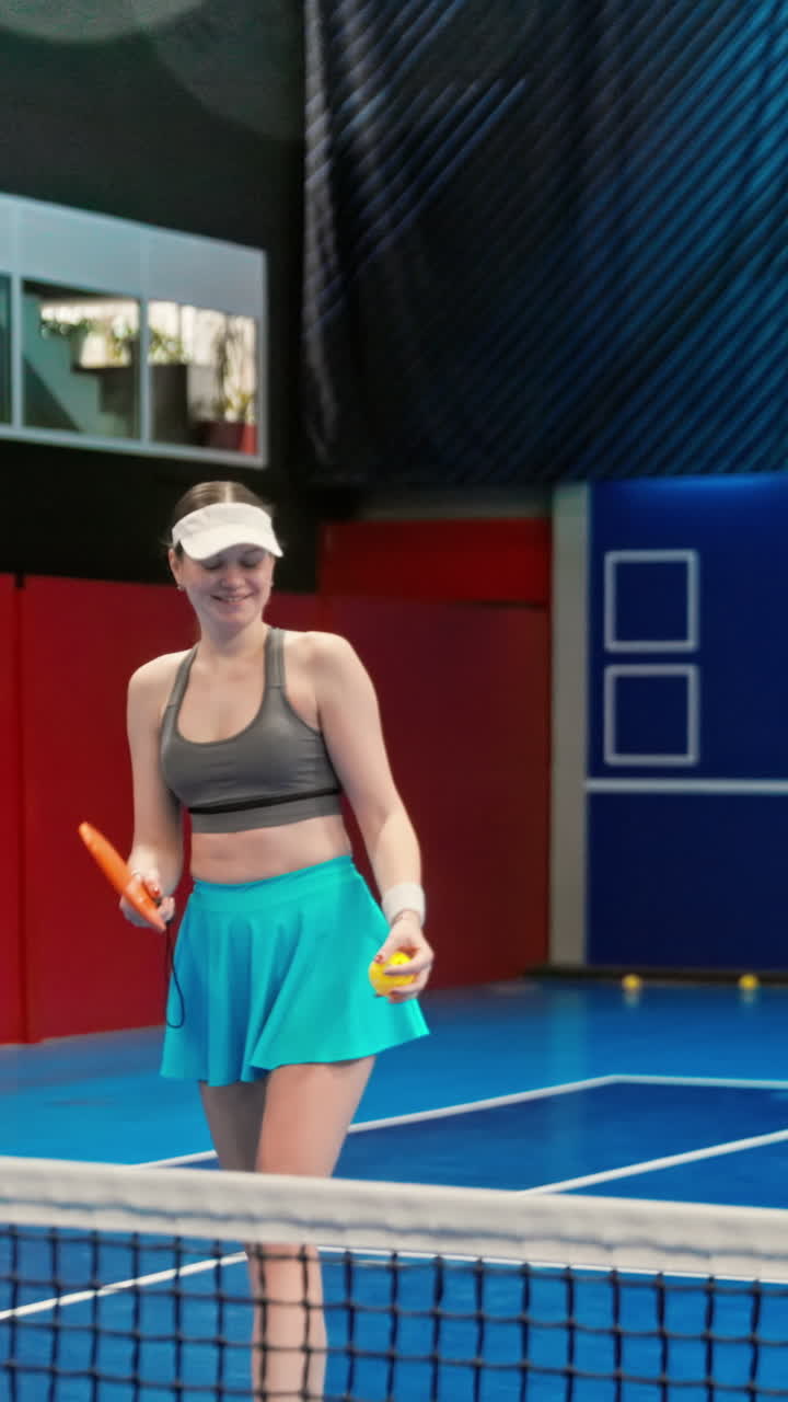 Two men and two women high-fiving after playing pickleball on a blue, inside court. Vertical
