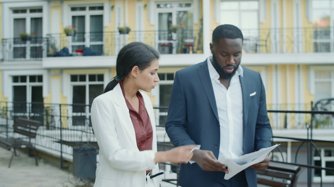 Serious business couple examining documents outdoors . Couple working outside