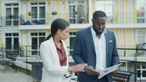 Serious-business-couple-examining-documents-outdoors-.-Couple-working-outside