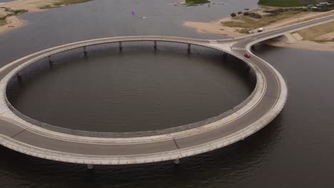 a drone over laguna garzon bridge as a red car drives over