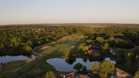 a green golf course may be seen next to lake geneva, a city on geneva lake in southeast wisconsin with two lakes
