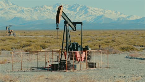 remote oil field in argentina overlooking andes mountain range, oil industry facilities