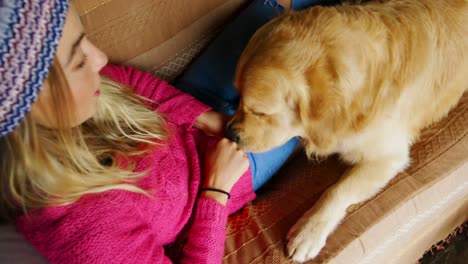 Woman-feeding-her-dog-on-sofa-at-home-4k