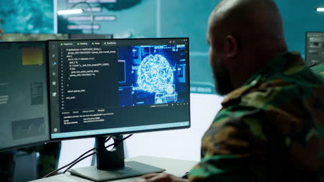 Military specialist monitors satellite data real time information on computer