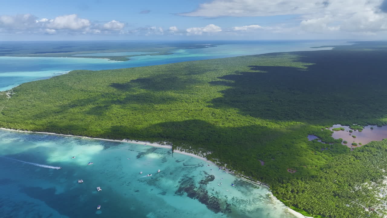 Overhead drone shot showing the picturesque green spaces and white sandy beaches located in the Dominican Republic in the Caribbean