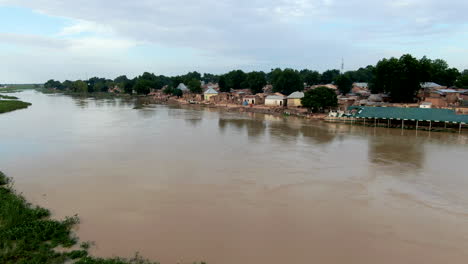 Der-Angeschwollene-Sokoto-Fluss-Nach-Überschwemmungen-In-Der-Stadt-Argungu-Im-Bundesstaat-Kebbi-In-Nigeria---Schlammiges-Wasser-Fließt-Vorbei